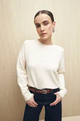 Sweater de punto fino color verde oliva, con calado delicado en hombros y mangas, cuello redondo y mangas largas.