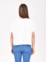 Remera blanca de corte recto con estampado de flores rojas y texto azul "PROFUMO DI FIORI".