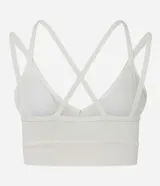 Top deportivo blanco de microfibra, con escote en V y tirantes finos que se cruzan en la espalda en forma de X.