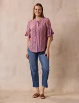Blusa de gasa estampada con cuello a la base, abertura central con botones y mangas cortas con volados.