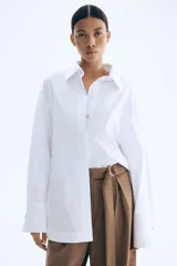 Pantalón sastrero marrón de punto con tiro alto, elástico oculto en la cintura, cierre decorativo, cinturón cosido con anillas en D de metal en un lateral y piernas ajustadas con pinzas para estilizar la silueta.