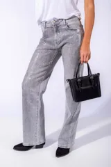 Pantalón de jean negro con apliques de lentejuelas plateadas.