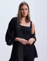 Pashmina de gasa negra con apliques de brillos plateados en los bordes.