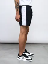 Short de baño negro con una banda vertical blanca en el lateral con el logo de Umbro en color rosa.