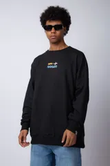 Buzo negro de corte oversize con cuello redondo y estampa de un avión sobre olas.