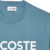 Remera negra de cuello redondo con logo Lacoste estampado en el pecho.