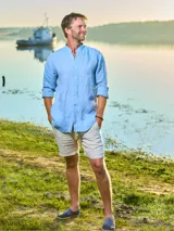 Camisa celeste de lino con cuello mao y mangas largas con botón para enrollar.