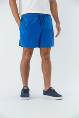Short de baño liso color azul eléctrico, con dos bolsillos delanteros y uno trasero. Confeccionado en tela ligera de secado rápido y logo en goma.