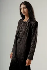 Blazer de mujer con silueta relajada y diseño sastrero, confeccionado en tejido negro con estampado jacquard floral.