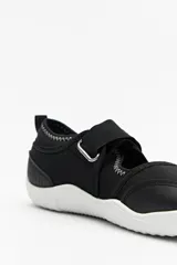 Guillerminas ergonómicas color beige, inspiradas en el calzado barefoot. De suela fina, plana y flexible, sin tacos ni soporte rígido. Cuenta con tira ajustable de velcro.