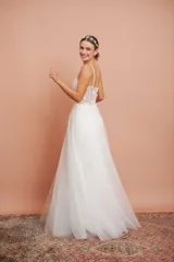 Vestido largo de microtul blanco con brillo y apliques de flores, con breteles finos y falda con vuelo. Ideal para quinceañeras.