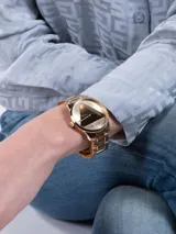 Reloj Guess dorado con pulsera de acero y esfera dorada con diseño triangular.