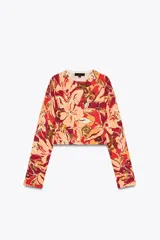 Top corto de punto con estampado floral en tonos rojo, naranja, verde y beige, cuello redondo y manga larga.