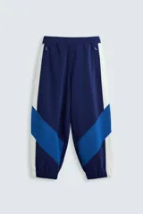 Pantalón deportivo azul marino con paneles laterales blancos y detalles en azul eléctrico. Corte relaxed fit, cintura elástica ajustable con cordón, bolsillos frontales ocultos y puños elásticos.