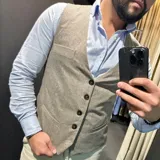 Chaleco azul marino de lana con cuello en V, cierre frontal con botones y bolsillos ribeteados.