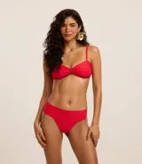 Top de bikini bandeau color rojo, confeccionado en microfibra acanalada. Tiene breteles ajustables y removibles, nudo en el centro, copa removible y lazo en la espalda.