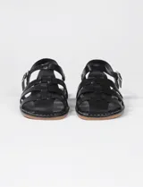 Sandalias negras de cuero sintético con múltiples tiras entretejidas, suela plana y tira trasera con hebilla.