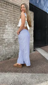 Pantalón largo a rayas verticales azules y blancas, de corte amplio y cintura elástica.