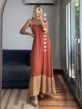 Vestido largo verde oliva con breteles finos regulables y corte a la cadera con volado color beige.