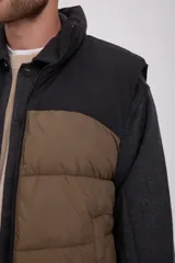 Chaleco acolchado sin mangas con cuello alto y cierre de cremallera. Bolsillos frontales. Confeccionado en tejido acolchado de varias capas cosidas, que proporciona una sensación cálida y aislante. Relleno de fibra sintética.