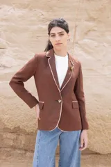 Blazer color chocolate de lino con solapas con borde en contraste color beige, cierre con un botón y corte entallado.