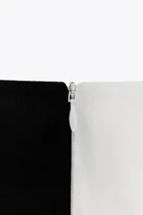 Vestido midi sin mangas de Zara Woman Collection, confeccionado en hilatura de algodón con estampado abstracto en blanco y negro. Tiene cuello barco, bajo con acabado en globo y cierre con cremallera oculta en la costura.