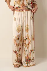 Pantalón palazzo color crema con estampado floral y de arabescos dorados.