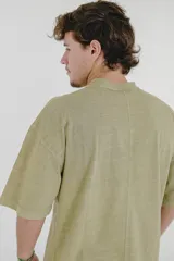 Remera color beige de corte holgado, con cuello redondo y bolsillo en el pecho.