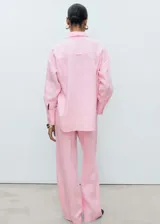 Camisa rosa de lino con cuello camisero, manga larga con puños abotonados, diseño oversize y cierre delantero con botones.