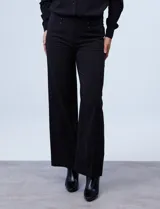 Pantalón negro de pierna ancha, marca Zac & Rachel. Pretina ancha con aplique de botones y bolsillos simulados con tachas.