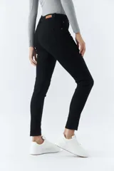 Pantalón de jean negro, corte skinny, tiro medio, con logo bordado y pasacinto.
