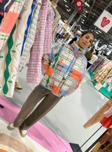 Campera puffer con estampado patchwork multicolor, cuello alto y bolsillos laterales.