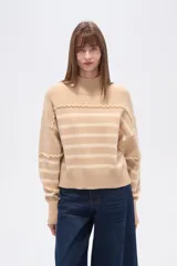 Sweater de punto color beige con rayas horizontales color crema, cuello alto y corte holgado. Presenta costuras decorativas en hombros y pecho.