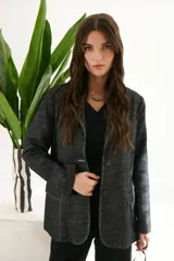 Blazer de mujer color gris oscuro con textura de jean/lino, corte oversize, hombreras, bolsillos frontales y pespuntes a contratono. Cierre frontal con botones.