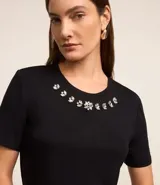 Blusa roja de mangas cortas confeccionada en viscosa con cuello redondo con apliques brillantes en formas florales.