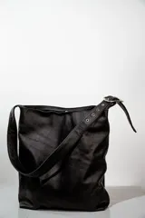 Cartera de cuero negra, con diseño minimalista y correa ajustable.