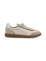 Zapatillas acordonadas de cuero color beige con suela de goma color caramelo y detalle plateado en el talón.