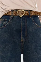 Cinturón con estampado animal print, hebilla dorada en forma de corazón y reverso negro.