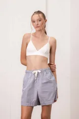 Short a rayas verticales azules y blancas de algodón, con cintura elástica y cordón ajustable. Incluye musculosa blanca de rib de regalo.