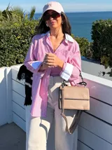 Camisa larga a rayas verticales rojas y blancas, con cuello y puños blancos.