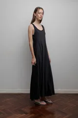 Vestido largo negro de corte evasé, sin mangas y escote redondo. Incluye un pañuelo gris claro.