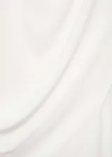 Blusa blanca sin mangas de tejido fluido con diseño cruzado y cuello redondo. Presenta cierre de cremallera en la parte posterior y detalles drapeados.