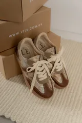 Championes acordonados color beige y dorado con suela marrón.