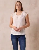 Blusa color beige en tejido elastizado, con cuello redondo y mangas cortas con aplique de crochet.