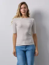 Remera color beige de corte ajustado, con cuello redondo y mangas cortas. Tejido acanalado de modal y elastano.
