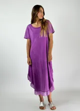 Vestido midi lila con textura arrugada, corte holgado, mangas cortas y ruedo con volados.