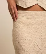 Pollera midi de punto color crema con diseño calado tipo ganchillo, corte recto y cintura elástica.