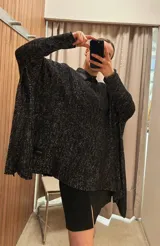 Poncho color beige de algodón tejido, con moldería oversize y tajos en los laterales.