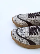 Championes urbanos Champion Shell con capellada de cuero con estampado animal print, detalles en cuero liso color marrón y suela de goma color caramelo.