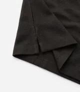 Polo de hombre de manga corta, color beige claro, con cuello mao y tapeta de dos botones.